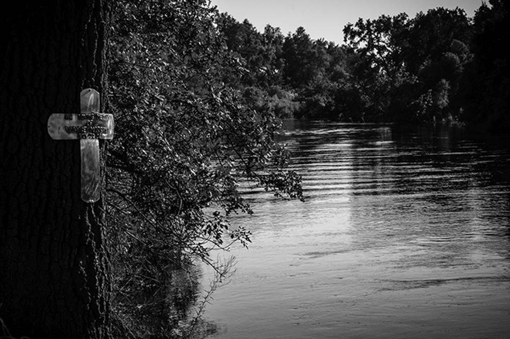 A memorial cross nailed to a tree, marks the spot where Wayne Morgan jumped into the river, broke his neck and died.