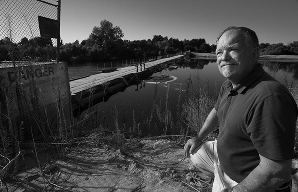 River activist and historian Randy MacFarland near the People's Weir, built in 1918, are the largest diversion gates on the Kings, near Kingsburg, Ca.