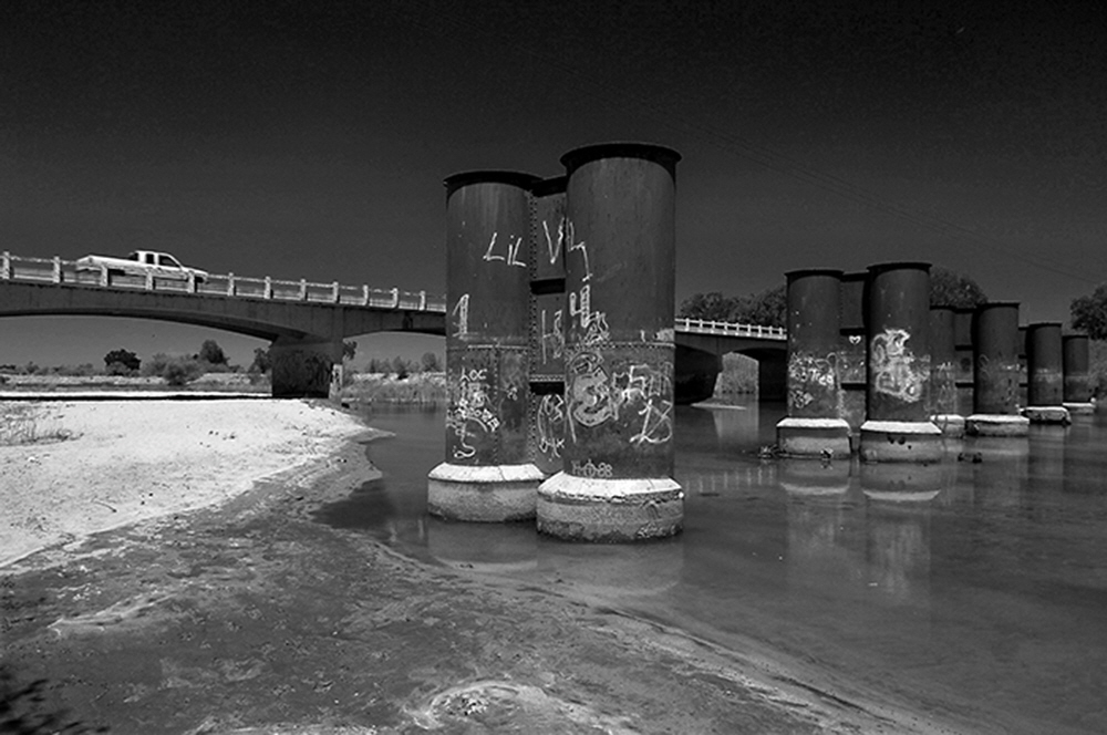 Over the lower Kings near Hanford Ca., the pilings of the old and the new bridge of the Kings River show the power of water.